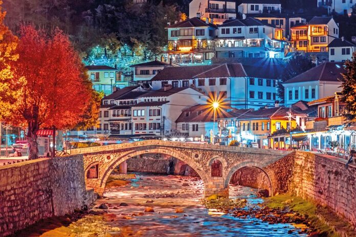 River with a stone bridge in downtown Prizren with buildings and trees at night, Pristina Kosovo River with a stone bridge in downtown Prizren with buildings and trees at night, Pristina Kosovo
