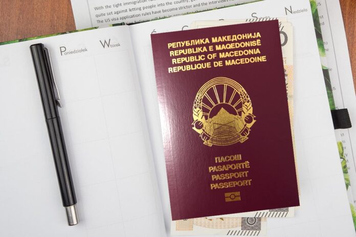 Top view of the Polish red passport with banknotes and documents on the wooden surface