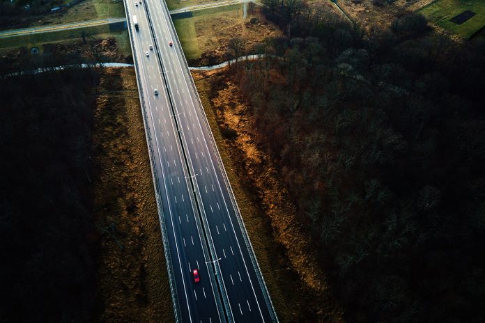 aerial-view-of-highway-with-moving-cars-2023-11-27-05-25-26-utc
