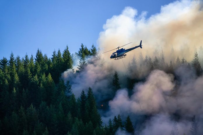 Helicopter fighting BC forest fires during a hot sunny summer day