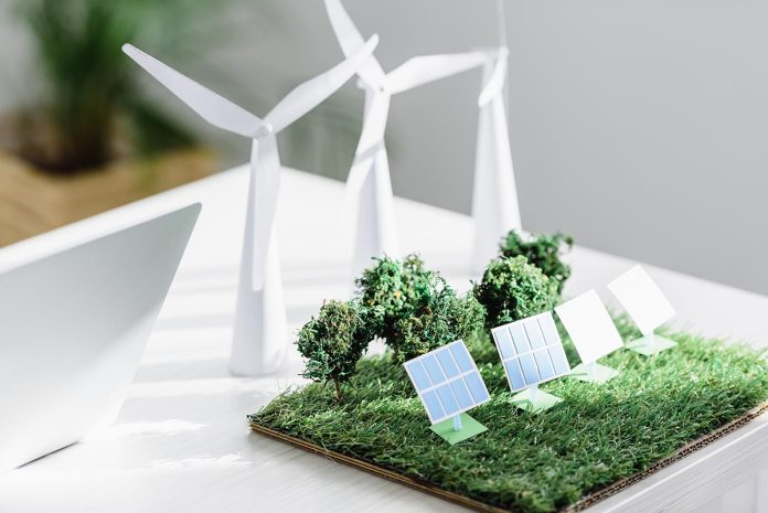 table with trees, windmills and solar panels models on grass in
