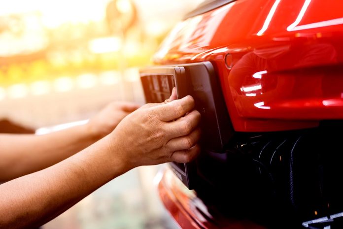 Technician,Changing,Car,Plate,Number,In,Service,Center.