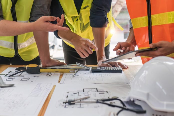Engineer,Teamwork,Meeting,,Drawing,Working,On,Blueprint,Meeting,For,Project