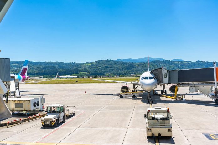 A large white airplane is parked on the tarmac at an airport