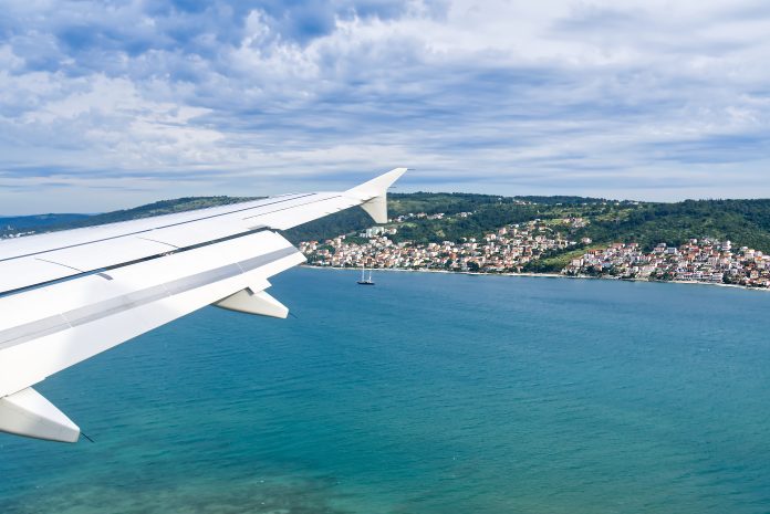 Aircraft landing in Split Croatia. Beautiful view from the porthole to aircraft wing, sea, city, sky