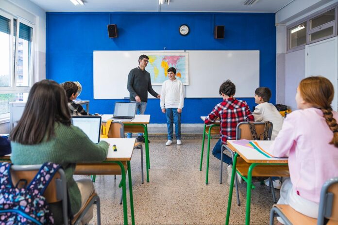 Geography teacher giving lesson to elementary school students