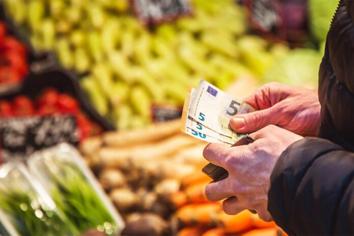 Man takes money out from wallet on market