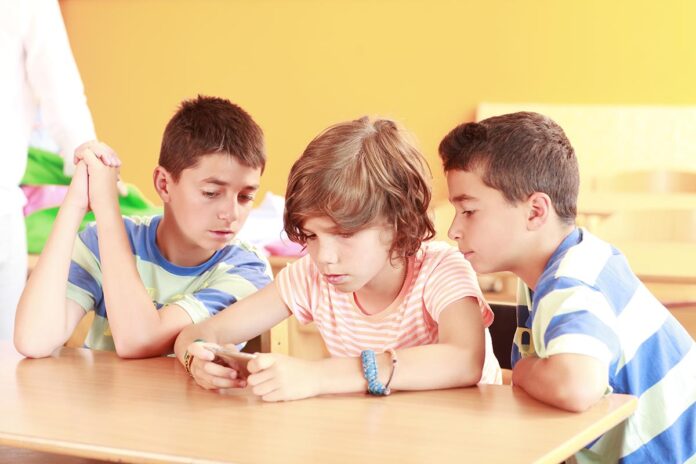group-of-young-friends-playing-with-a-mobile-phone-2026
