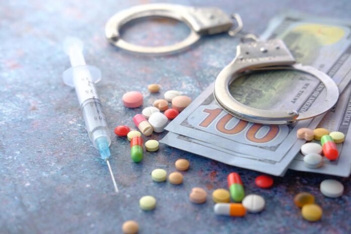 Close up of handcuff , cash and medical pill on dark background