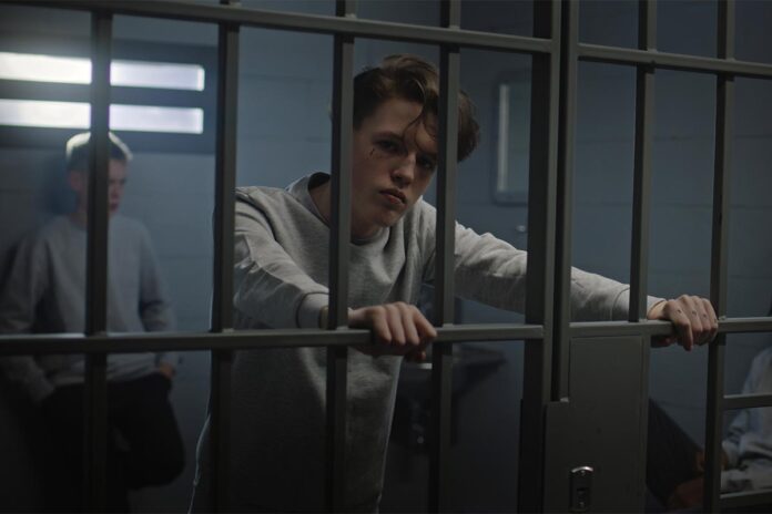 Multicultural,Teenage,Prisoners,Behind,Metal,Bars,In,Prison,Cell,Look