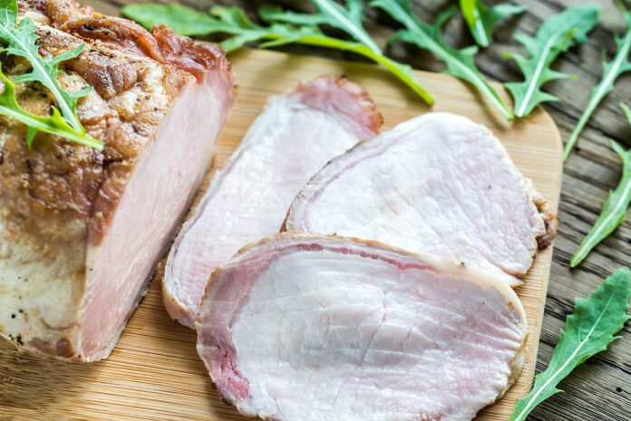 Baked meat with fresh rocket salad on the wooden board