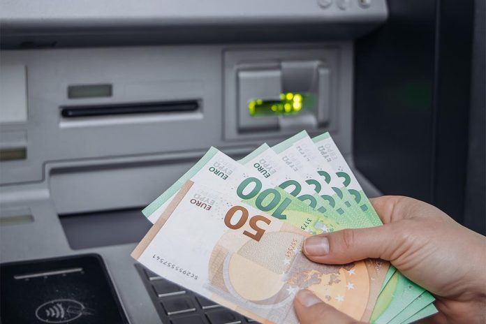 Person,Is,Withdrawing,Cash,From,An,Atm,,Holding,Euro,Banknotes,