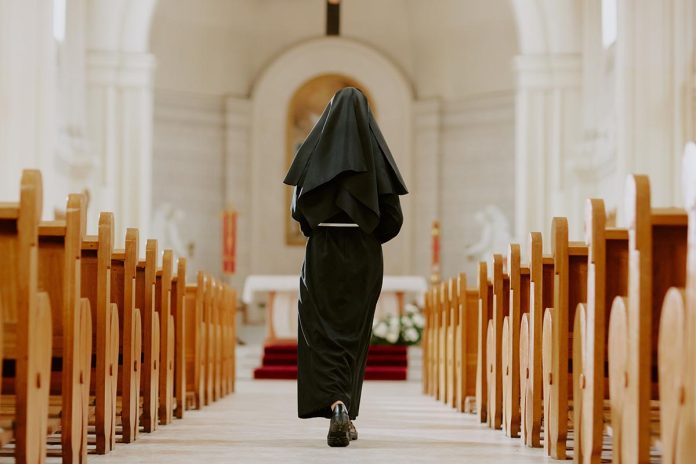 Rear,View,Wide,Shot,Of,Unrecognizable,Catholic,Nun,Walking,Along