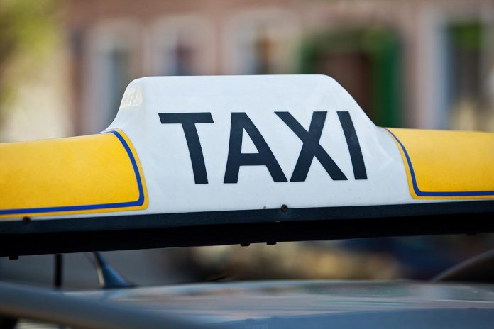Taxi sign on a car roof - close-up