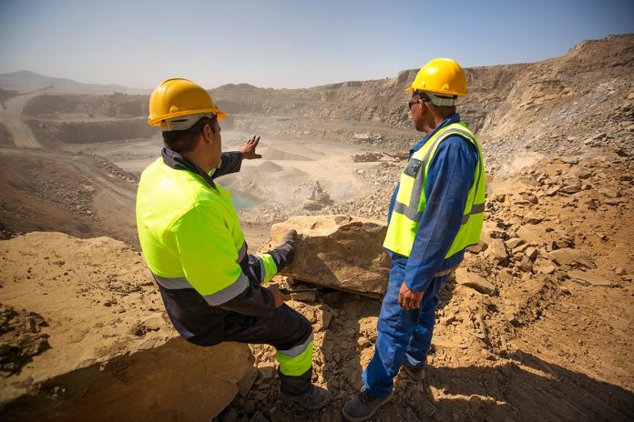 Two quarry workers looking over quarry